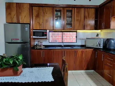 a kitchen with wooden cabinets and a table in it at Alquiler luque in Mina Clavero