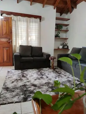 a living room with a black couch and a rug at Alquiler luque in Mina Clavero
