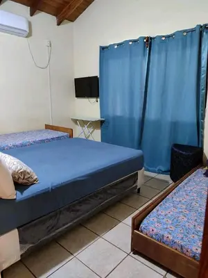 a room with two beds and a tv in it at Alquiler luque in Mina Clavero