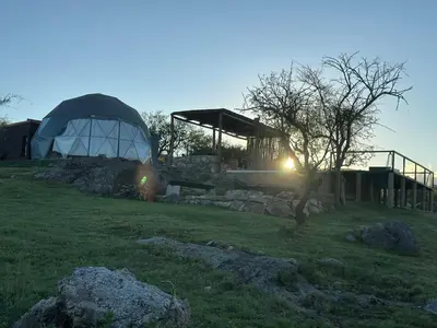 a dome house with a tree in a field at La Loma Domo Suite in Cavalango