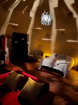 a bedroom with a bed and a couch and a chandelier at La Loma Domo Suite in Cavalango