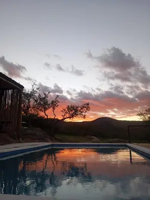 a swimming pool with a sunset in the background at La Loma Domo Suite in Cavalango