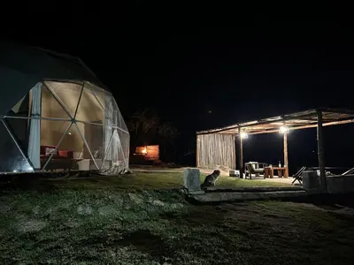a iguana sitting in front of a tent at night at La Loma Domo Suite in Cavalango