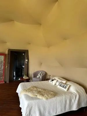 a bedroom with a large bed with a white blanket at La Loma Domo Suite in Cavalango