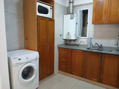 a kitchen with a washing machine and a microwave at Departamento con Encanto Nueva Córdoba 2 in Cordoba