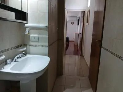 a bathroom with a white sink and a hallway at Departamento con Encanto Nueva Córdoba 2 in Cordoba