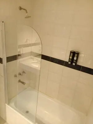 a shower with a glass door next to a tub at Monoambiente Centrico in Cordoba