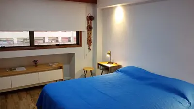 a bedroom with a blue bed and a window at Monoambiente Centrico in Cordoba