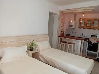two beds in a room with a kitchen at Monoambiente blvd San juan in Cordoba