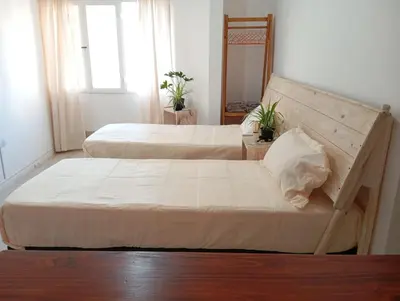 two beds in a small room with a window at Monoambiente blvd San juan in Cordoba