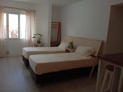 a hotel room with two beds and a window at Monoambiente blvd San juan in Cordoba