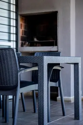 a wicker table and chairs on a patio at BUENA VIDA I Apart Hotel in Villa Icho Cruz