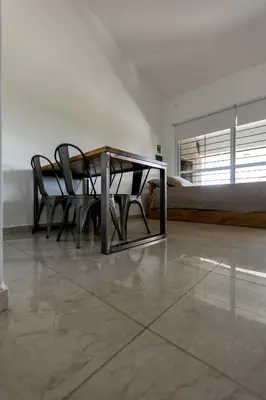 a table and chairs in a room with a bed at BUENA VIDA I Apart Hotel in Villa Icho Cruz