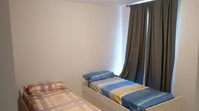 two beds in a room with a window at Departamento zipoli in Cordoba