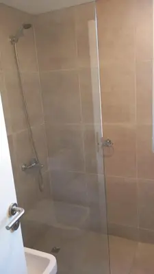 a shower with a glass door next to a toilet at Departamento zipoli in Cordoba