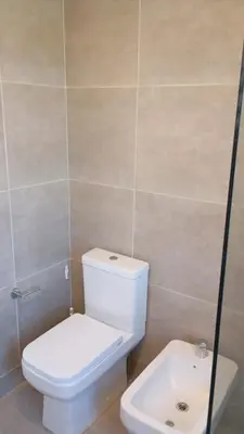 a bathroom with a white toilet and a sink at Departamento zipoli in Cordoba