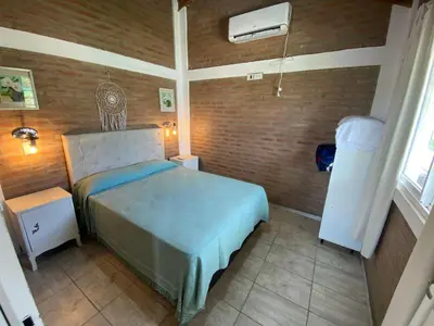a bedroom with a bed and a brick wall at Cabañas Las Serranitas 3 in Villa Parque Siquiman