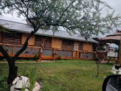 a log cabin with a tree in front of it at Cabañas Las Serranitas 3 in Villa Parque Siquiman