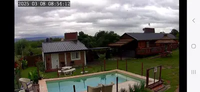 a house with a swimming pool in front of a house at Cabañas Las Serranitas 3 in Villa Parque Siquiman