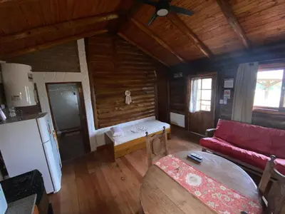 a living room with a red couch and a refrigerator at Cabañas Las Serranitas 3 in Villa Parque Siquiman