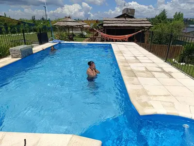 a woman is standing in a swimming pool at Cabañas Las Serranitas 3 in Villa Parque Siquiman