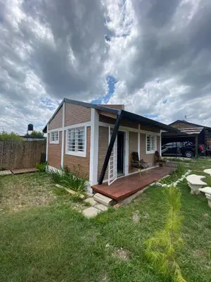 a small house with a deck in a yard at Cabañas Las Serranitas 3 in Villa Parque Siquiman