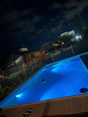 a large blue swimming pool at night at Cabañas Las Serranitas 3 in Villa Parque Siquiman
