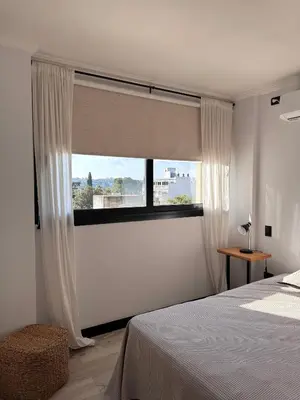 a bedroom with a bed and a large window at Espectacular Departamento Carlos Paz in Villa Carlos Paz