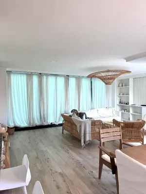 a living room with a couch and chairs and windows at Espectacular Departamento Carlos Paz in Villa Carlos Paz
