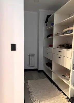 a white closet with white shelves and a rug at Espectacular Departamento Carlos Paz in Villa Carlos Paz