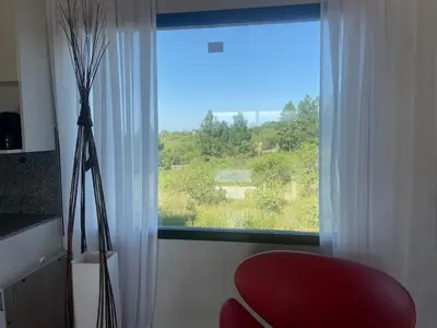 a red chair sitting in front of a window at Verdena in Villa Amancay