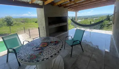 a patio with a table and chairs on a balcony at Verdena in Villa Amancay