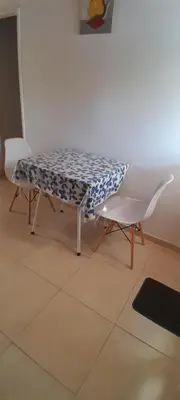 a table and a white chair in a room at MabiSil in Mina Clavero