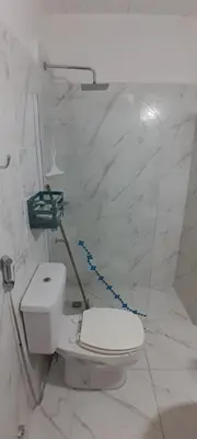 a white bathroom with a toilet with a blue rope at MabiSil in Mina Clavero