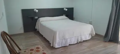 a bedroom with a white bed and a chair at MabiSil in Mina Clavero