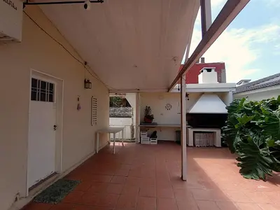 an outdoor patio with a roof with a stove at Alquilo Dpto en Villa Carlos Paz in Villa Carlos Paz
