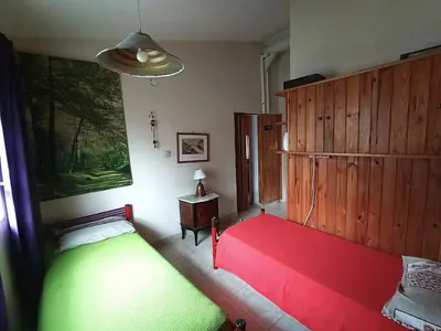 a bedroom with two beds and a red bed at Alquilo Dpto en Villa Carlos Paz in Villa Carlos Paz
