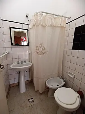 a bathroom with a sink and a toilet and a shower curtain at Alquilo Dpto en Villa Carlos Paz in Villa Carlos Paz