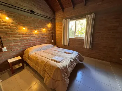 a bedroom with a large bed in a brick wall at Casa Terra in Mina Clavero