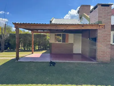 a black cat sitting in front of a house at Casa Terra in Mina Clavero