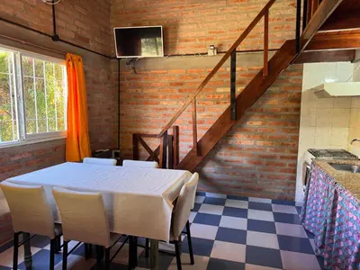 a dining room with a table and some stairs at Casa Terra in Mina Clavero