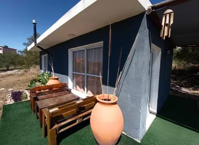 two large vases sitting on the porch of a house at Cabaña La Abuela Chicha - Tanti in Tanti
