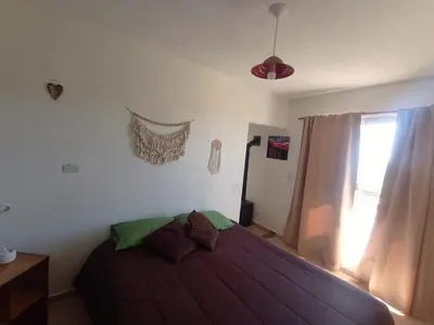 a bedroom with a large bed with a window at Cabaña La Abuela Chicha - Tanti in Tanti