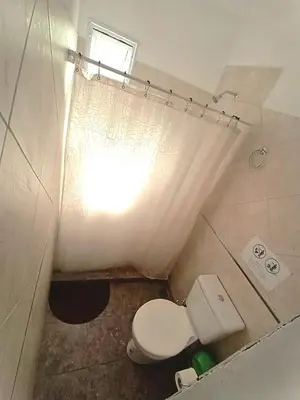 a small bathroom with a toilet and a window at Cabaña La Abuela Chicha - Tanti in Tanti