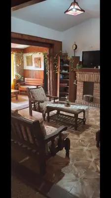 a living room with two benches and a fireplace at Independencia in Santa Rosa de Calamuchita