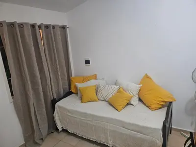 a bed with yellow pillows on it in a room at Cabañas Kay Pacha in San Antonio de Arredondo