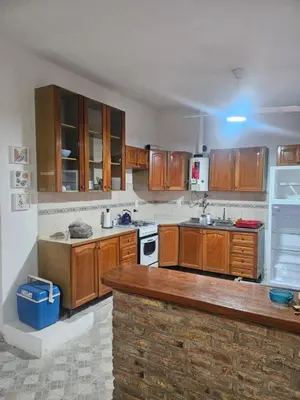 a kitchen with wooden cabinets and a counter top at Cabañas Kay Pacha in San Antonio de Arredondo