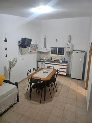 a kitchen with a table and chairs in a room at Cabañas Kay Pacha in San Antonio de Arredondo