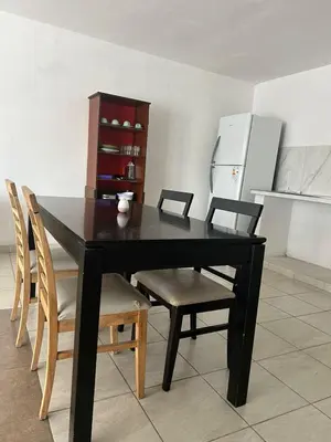 a black dining room table with chairs and a refrigerator at Depto 3 in Río Cuarto
