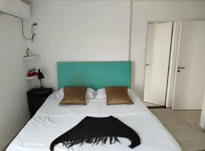 a bedroom with a bed with a black and white comforter at Departamento in Cordoba